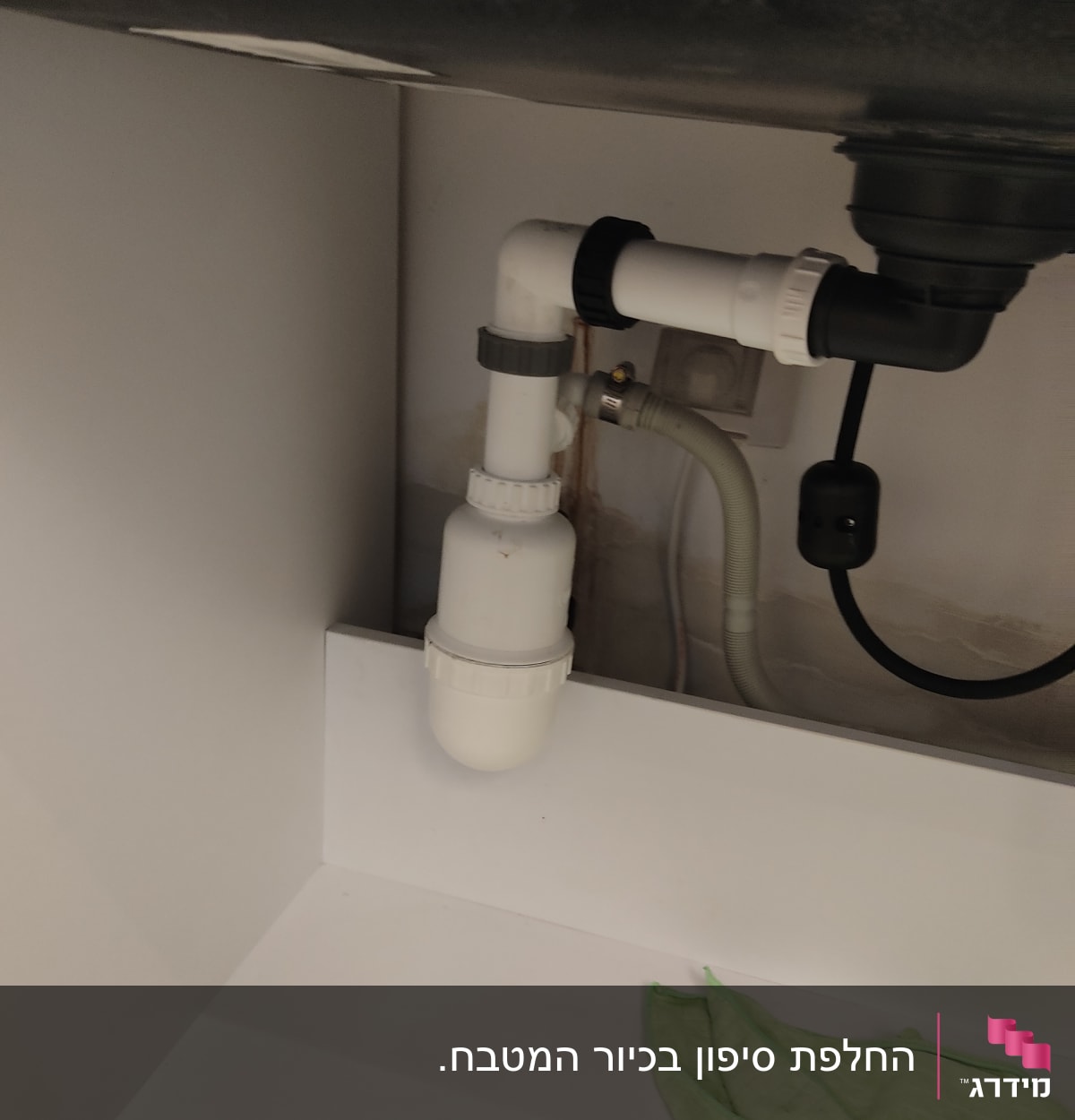 צנרת פלסטיק מתחת לכיור עם מחבר זוויתי